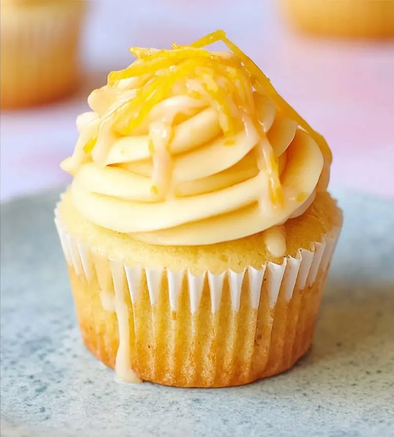 Soft Butter Lemon Cupcakes with frosting and lemon zest on cooling rack